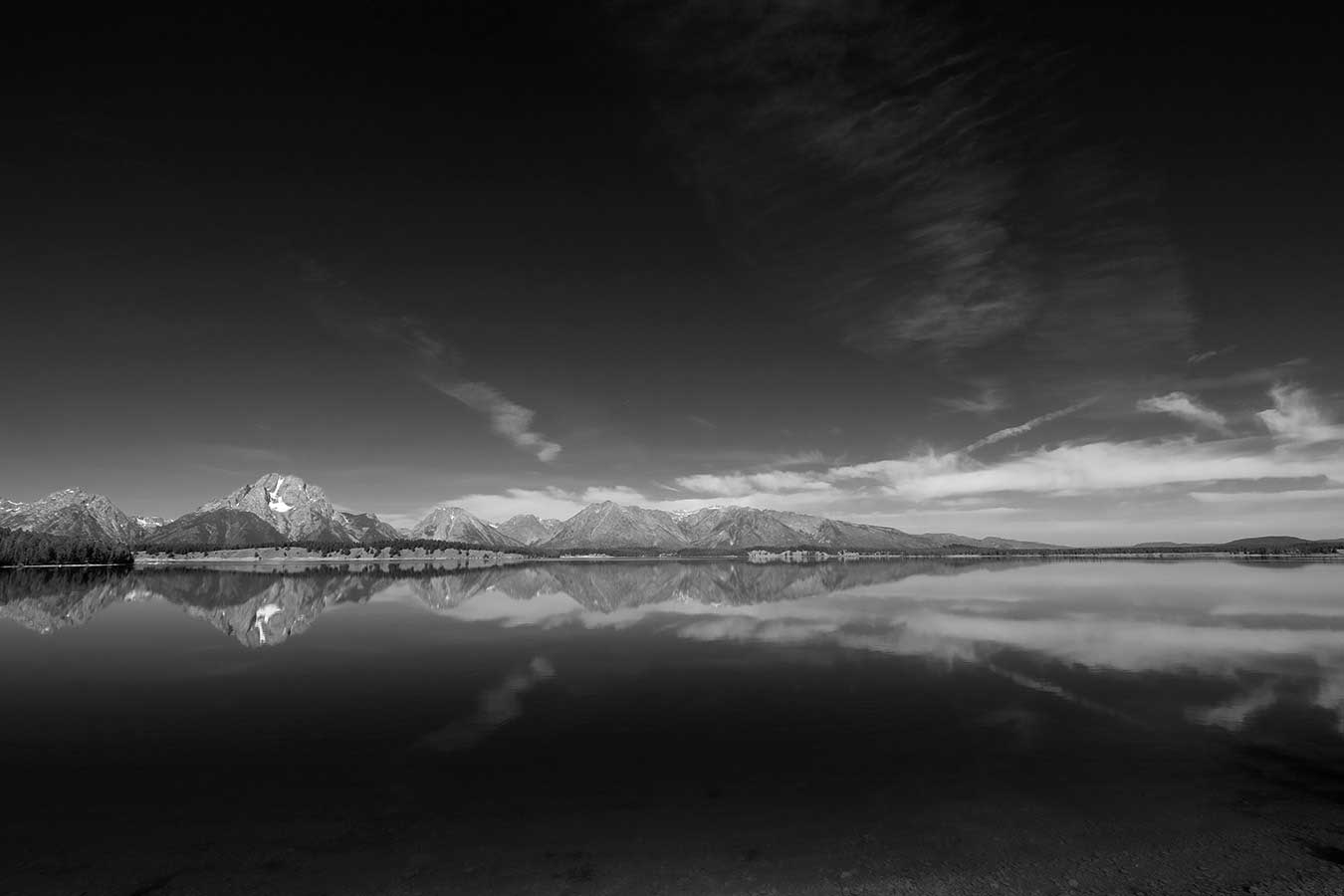 Black and white. Mount Moran and the surrounding Tetons are perfectly reflected in a reservoir.